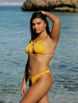 Model im Bikini Top und Bottom in gelb premium Stoff gerippt feminin am Meer