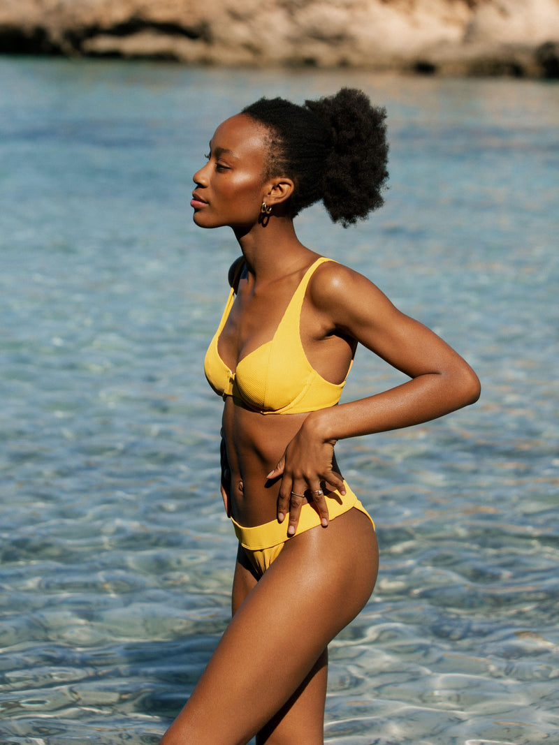 Frau im Bikini Top und Bottom gelb gerippt von Palmar im Meer