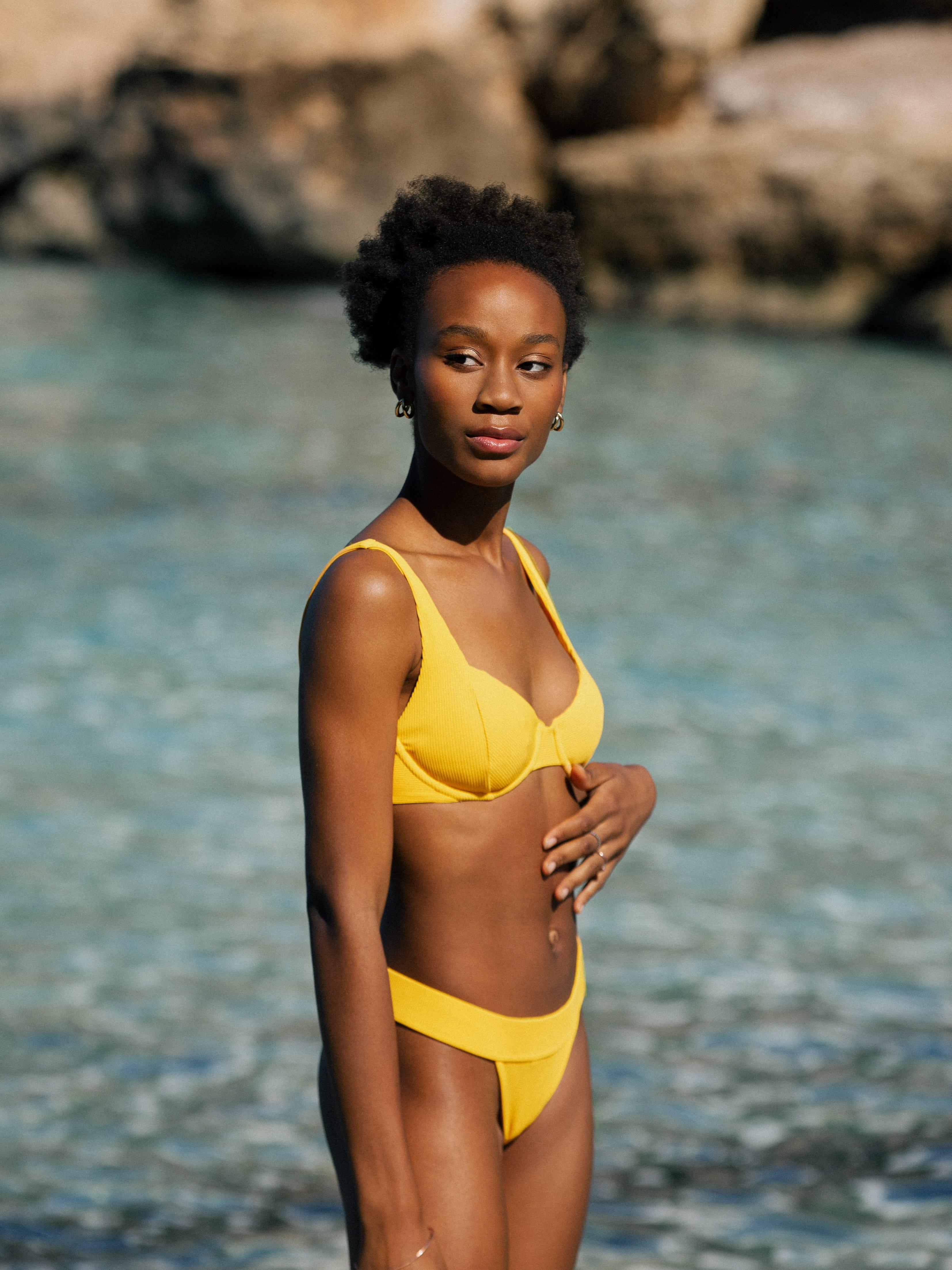 Model im Bikini Set gelb gerippt am Meer von Palmar