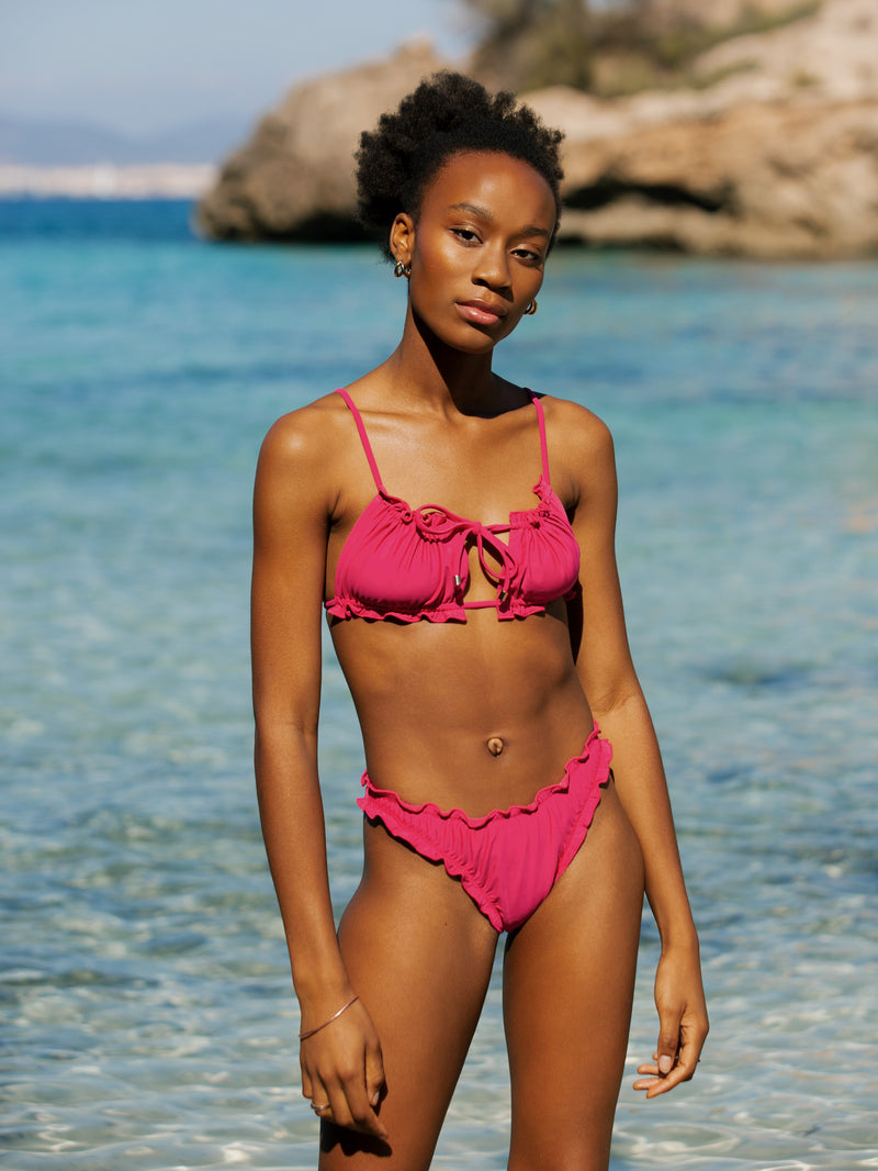 Model im Bikini pink nachhaltig aus recyceltem Stoff Palmar Swimwear am meer